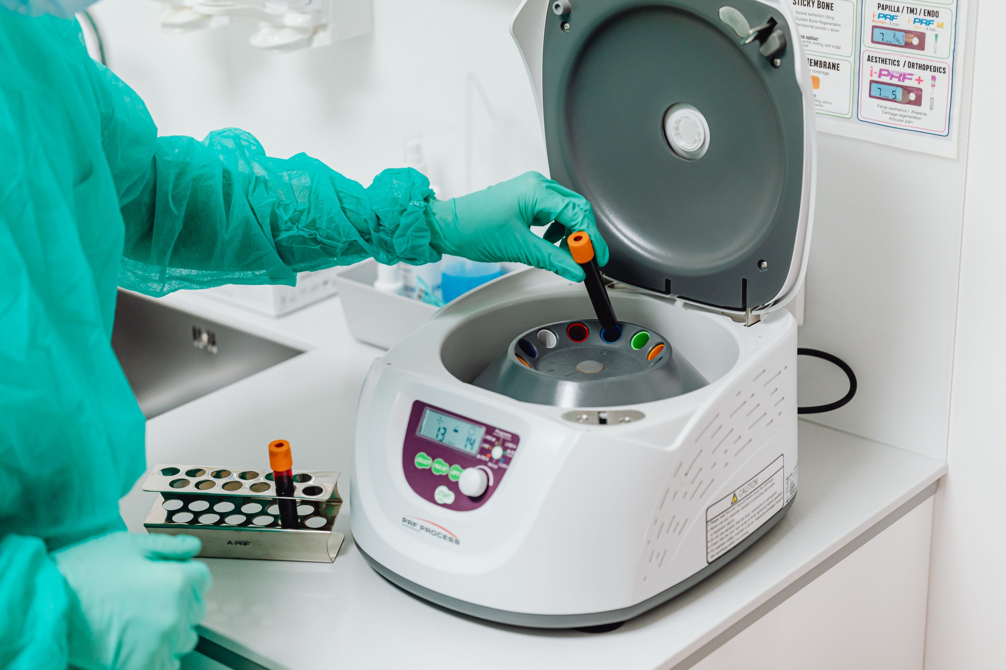 Lab technician operating a centrifuge at the bench